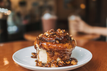 Caramel bun bakery dessert served on wooden table in the cafe.