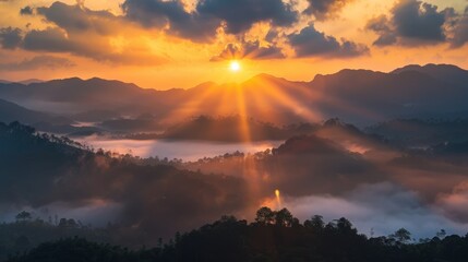 Sunrise casting warm light over misty mountains