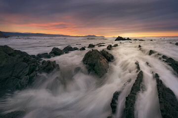 Sunset on Barrika beach, Bizkaia, with the waves entering with force among the flysch