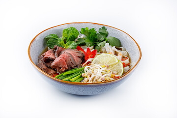 Pho Bo traditional Soup with beef, rice noodles, ginger, lime, chili pepper in bowl. Close up. Vietnamese and Asian cuisine.