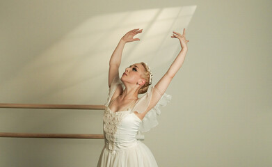 Ballet Dancer Reaching Towards Light in Graceful Studio Performance