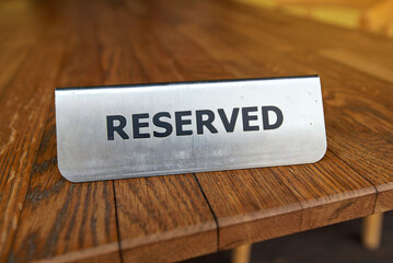 Reserved plate table sign in restaurant outdoor terrace, exclusive spot for guests. Reserved plate sign on table, reservation for guests.