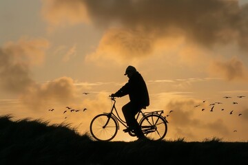 Obraz premium Silhouette of a Cyclist Riding a Bicycle at Sunset