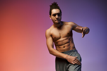 A young African American man dances against a vibrant, colorful gradient background.