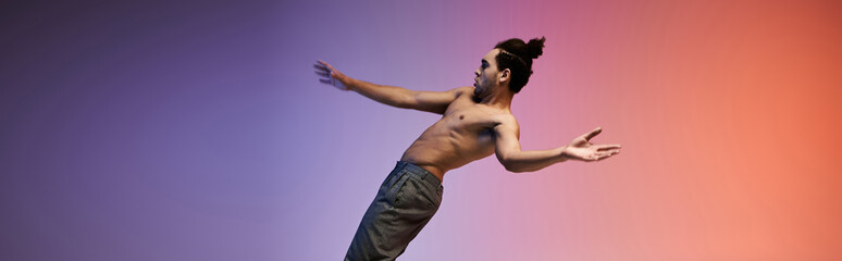 A young African American man dances against a colorful gradient background, expressing his artistry...