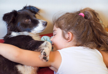 Kid hugging her stray dog at home 