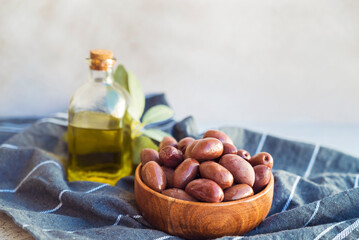 Olives kalamata in wooden bowl and olive oil