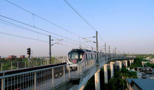 Delhi metro and the metro station. Metro rail in delhi. Dmrc metro entering the station.