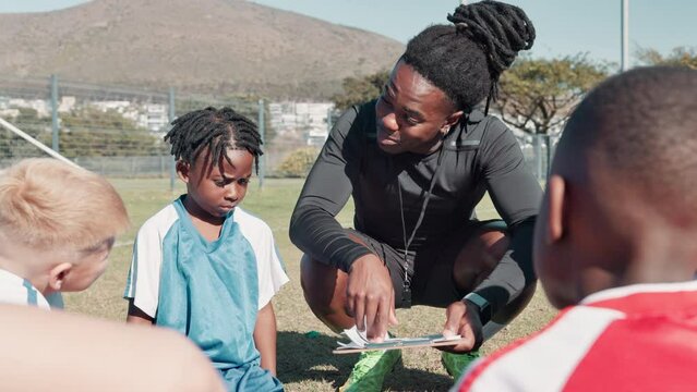 Coach, children and huddle with clipboard for soccer, formation or game plan with diversity on field. Man, football and kids in scrum with checklist for strategy, advice or mentorship for competition