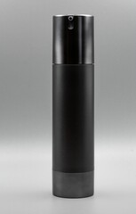 Black matte cosmetic spray bottle on a gray background