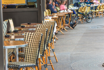 Traditional terrace in street cafe with tables and chairs in Paris, France