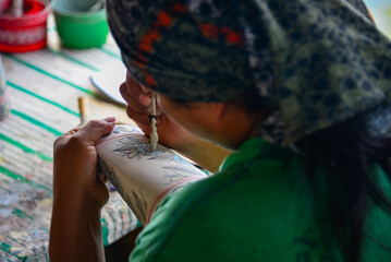 Woman Hand Paints a Ceramic Vase