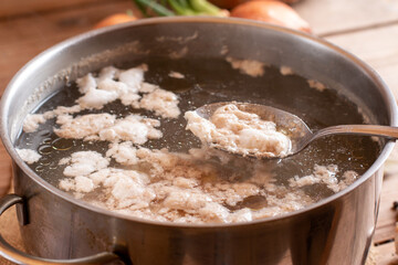 Foam in a boiling pot while cooking broth. Bone broth