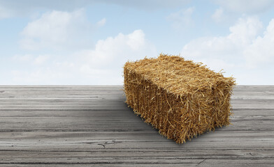 Bale of hay background as an agriculture farm and farming symbol of harvest time with dried grass straw as a bundled tied haystack on old grunge wood.