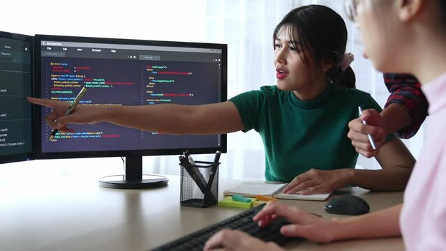 Slow motion back end software developer engineer for computer programming working together on debugging writing computing code, solving complex algorithms display on monitor in office. Burgeoning