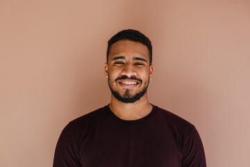Male portrait of young latin (african american) adult looking at camera with a natural smile