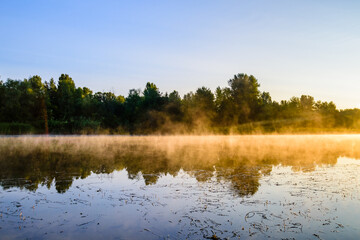 Fog above the water surface. Sunrise at river