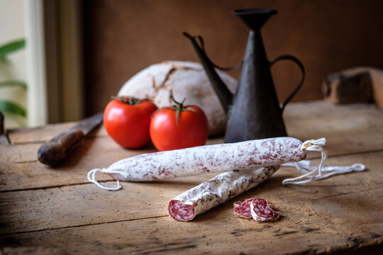 Various cured meats with tomatoes and vintage kitchen props