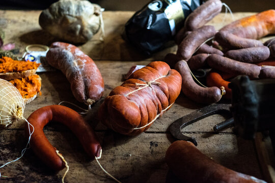 Variety of fresh and cured sausages on a rustic wooden table