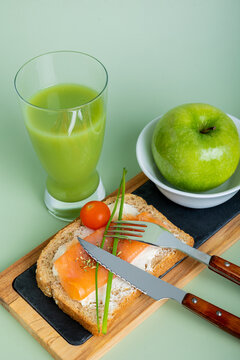 Healthy breakfast options with salmon, apple, and cucumber and apple juice