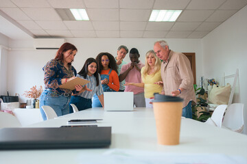 Diverse team collaborates over documents in modern office
