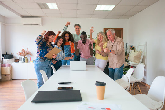 Diverse team celebrating success in modern office