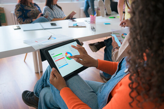 Team analyzing digital data on tablet in office meeting