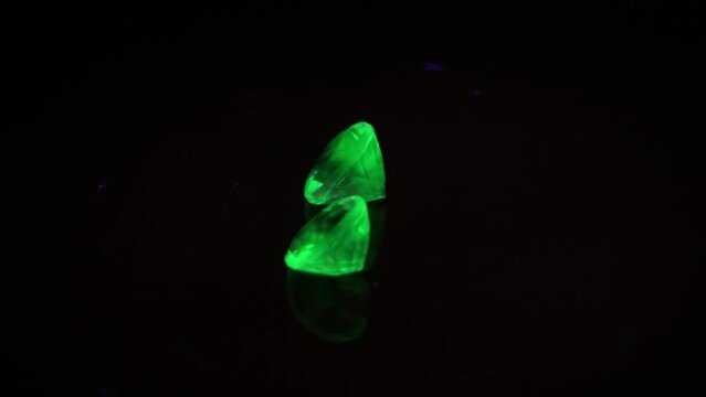 natural green opal hyalite under uv light on the black background