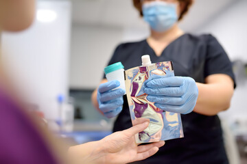 A nurse in the laboratory offers the patient a medical balloon for blowing to perform a test for Helicobacter