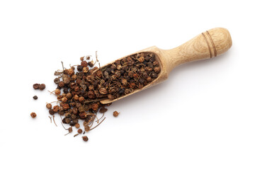 Top view of a wooden scoop filled with dry Organic Black nightshade or Makoy (Solanum nigrum) fruit. Isolated on a white background.
