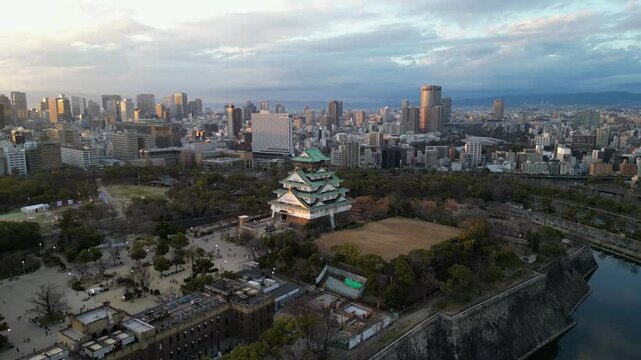 Aerial view of Osaka Castle flying over and revealing the Osaka skyline.