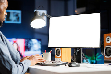 African american man checks white screen on computer, teleworking and using blank display on...