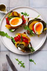 Bruschetta with cream cheese, baked bell peppers, arugula and soft-boiled egg..selective focus
