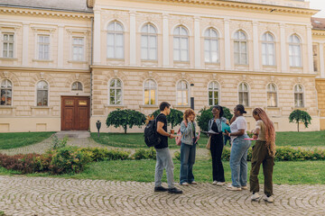 Full length shot of diverse students standing at campus with textbooks
