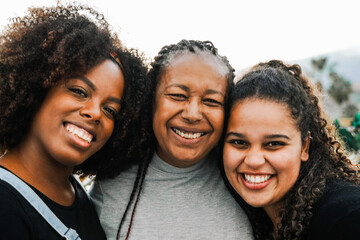 Happy African mother and daughters smiling at camera. Diversity and Love family concept