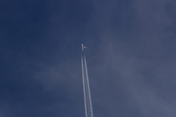 Airplane flying in the blue sky with white clouds in the background	