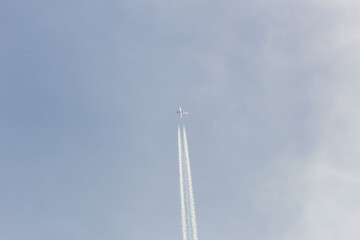 Airplane flying in the blue sky with white clouds in the background	