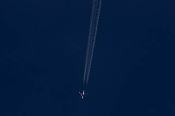Airplane flying in the blue sky with white clouds in the background	
