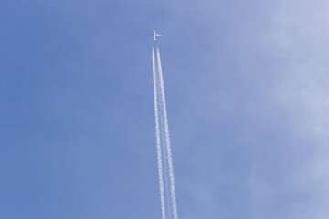 Airplane flying in the blue sky with white clouds in the background	