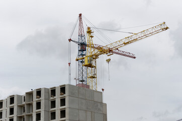 construction crane against the background of an unfinished building