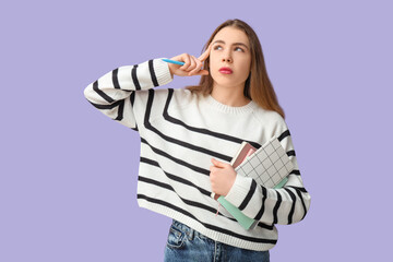 Thoughtful young woman holding notebooks and pen on lilac background. Reminder concept