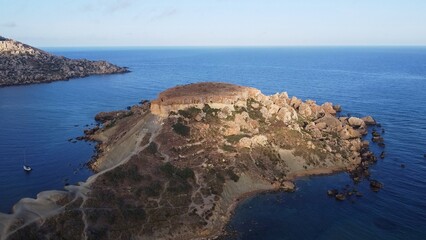 Qarraba Bay flat rock cape Malta, Aerial establishing shot in the morning sunlight. High quality photo