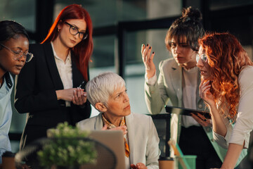 Upset senior businesswoman criticizing her interracial team at office.