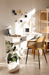 Interior of living room with workplace, pin board and plants