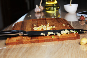 Finely chopped garlic on the kitchen board. The Process of Making Garlic Hot Butter