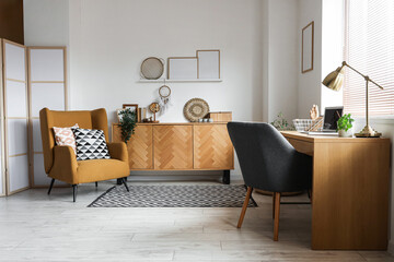 Interior of living room with workplace, commode and armchair