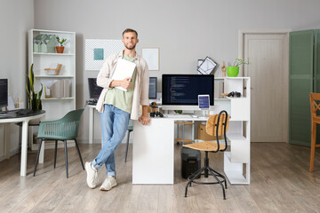 Young bearded programmer with laptop in office