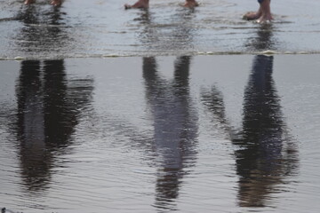 Reflections of people dancing in the ocean