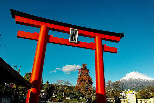 Shizuoka, Japan - November 13 2023 : A large torii gate at the entrance to Fujisan Hongu Sengen Taisha temple with Mount Fuji at Fujinomiya, Japan.