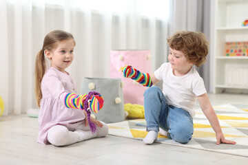 Cute little children playing with funny sock puppets in kindergarten